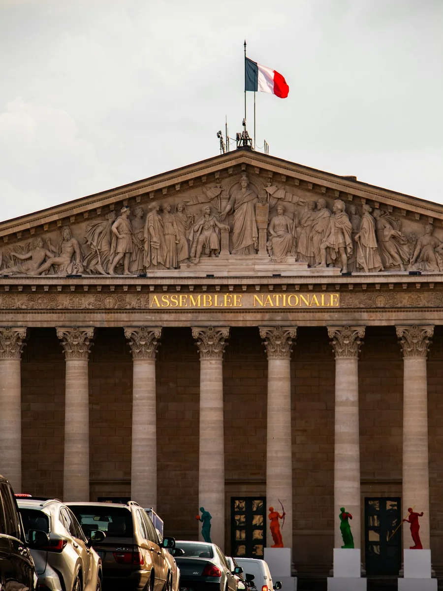 La façade à colonnes du Palais-Bourbon, siège de l'Assemblée nationale, surmontée du drapeau français