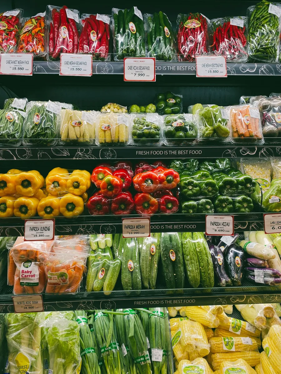 Rayons de fruits et légumes emballés dans un supermarché, avec leurs étiquettes de prix