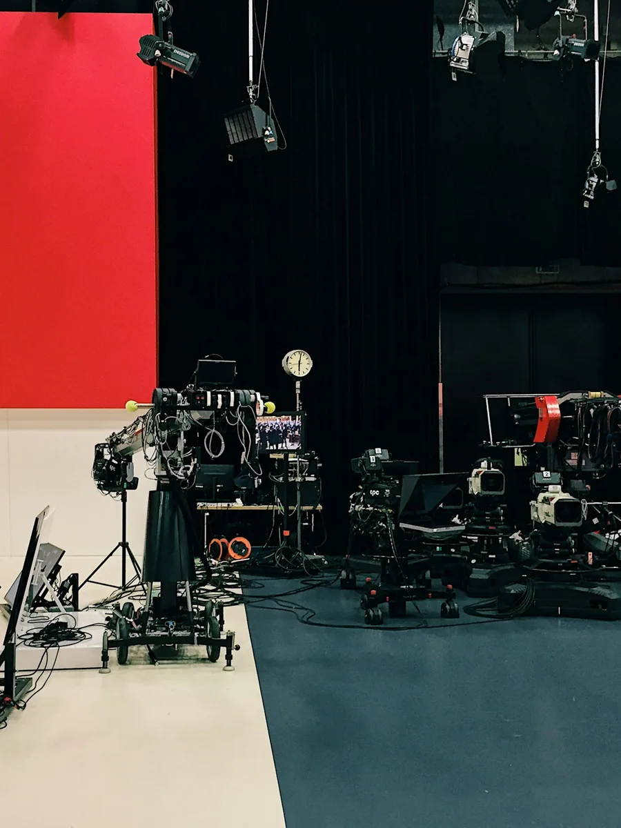 Un plateau de télévision plongé dans la pénombre, avec des caméras et des projecteurs