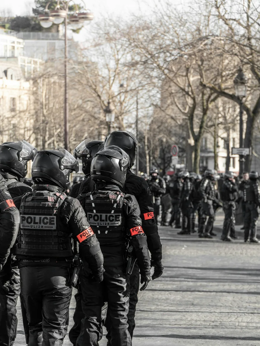 Des policiers casqués, de dos, en tenue de maintien de l'ordre, lors d'une manifestation à Paris