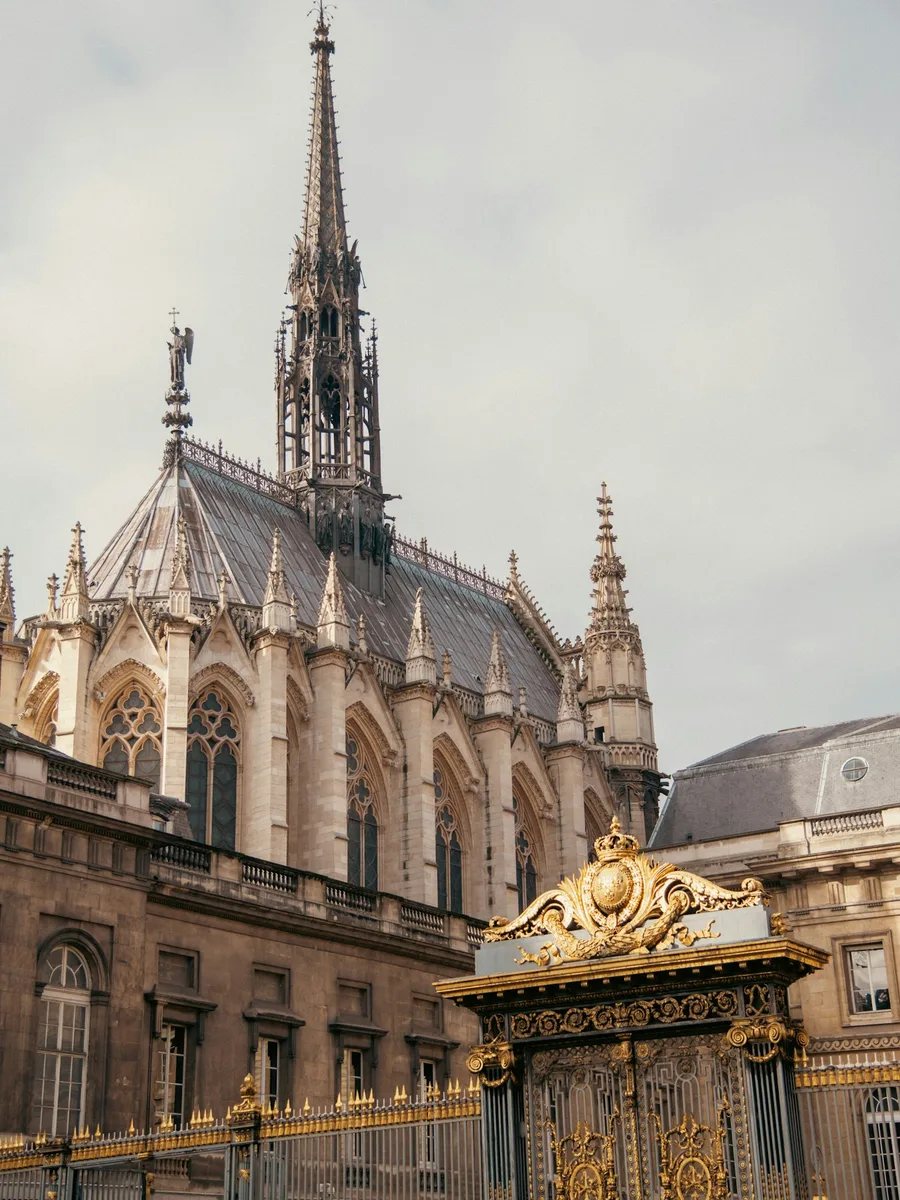 La flèche de la Sainte-Chapelle au-dessus des grilles dorées du Palais de justice, sur l'île de la Cité à Paris