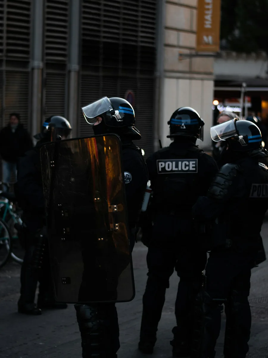 Des policiers casqués et équipés de boucliers alignés dans une rue
