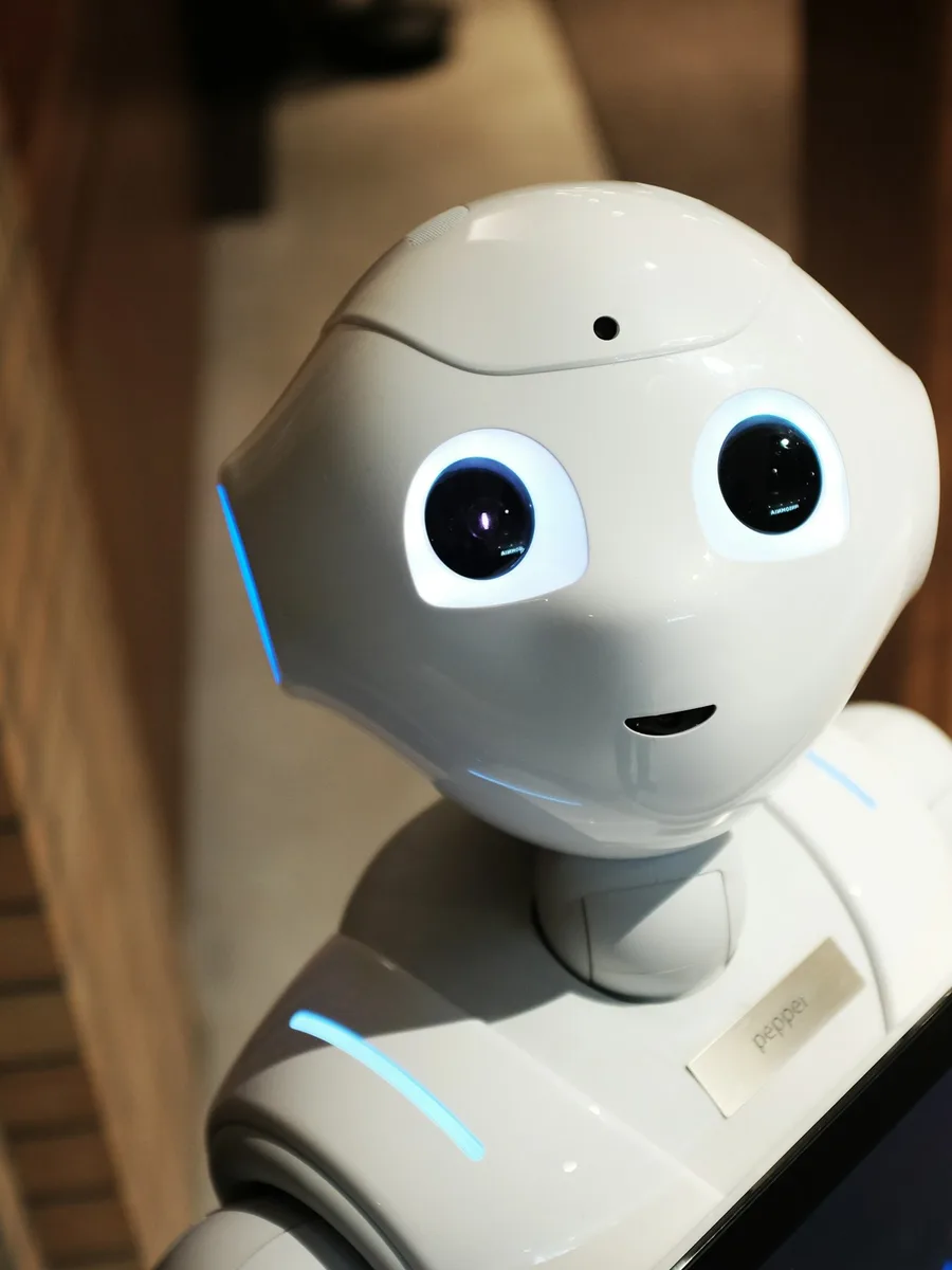 Gros plan sur la tête d'un petit robot humanoïde blanc aux grands yeux noirs