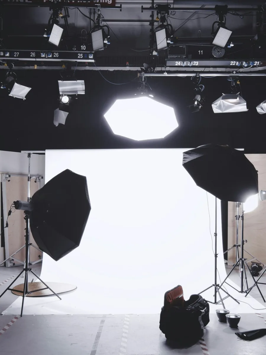 Un plateau de tournage vide, avec projecteurs et réflecteurs suspendus