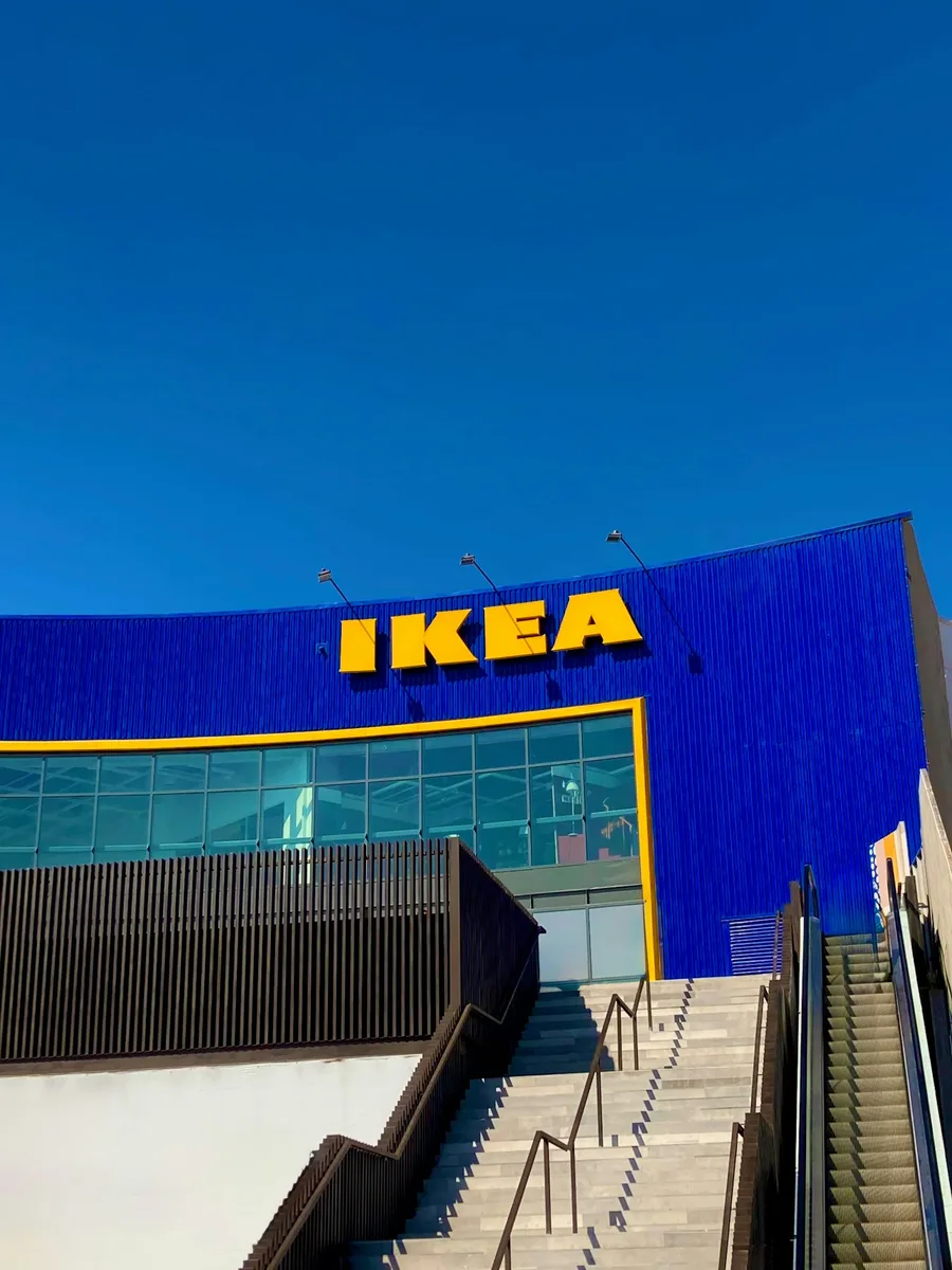La façade bleue d'un magasin Ikea et son enseigne jaune, sous un ciel bleu