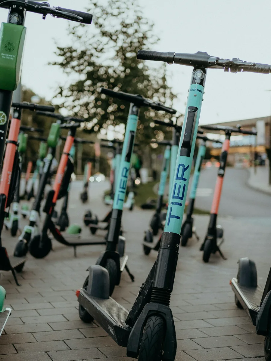 Des trottinettes électriques en libre-service alignées sur un trottoir