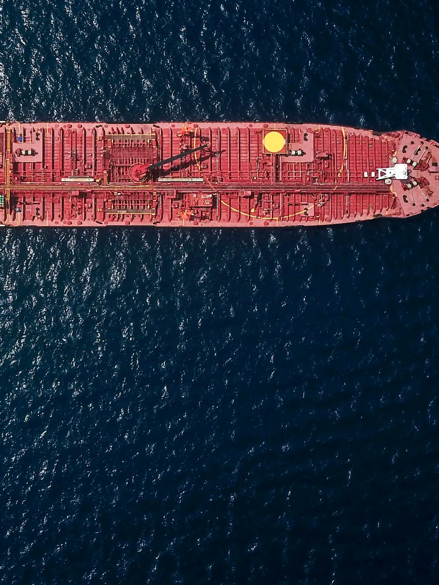 Un pétrolier rouge vu du ciel, naviguant en pleine mer.