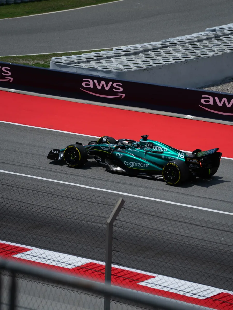 Une Formule 1 verte en pleine course le long d'un muret de circuit