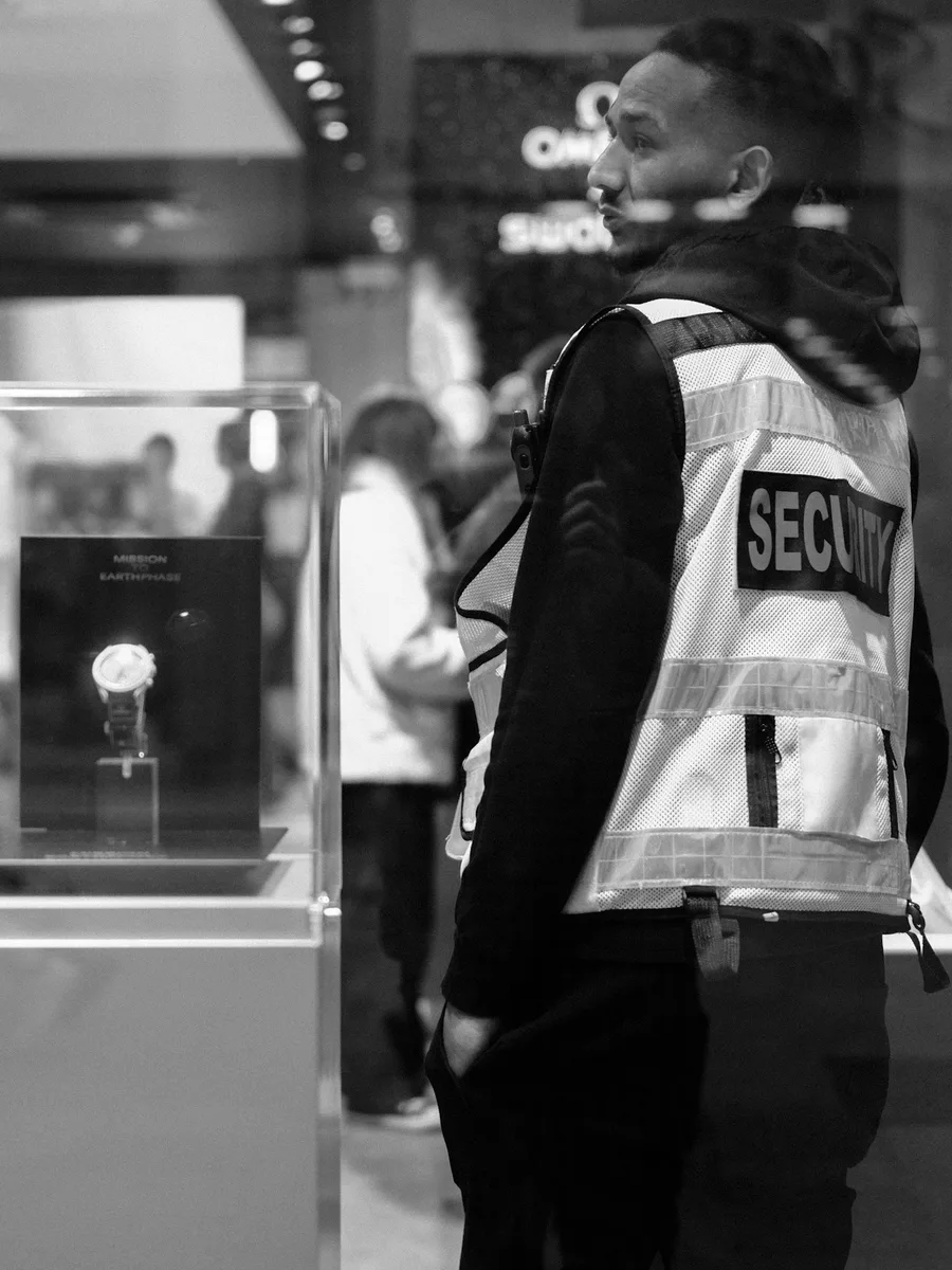 Un agent de sécurité en gilet réfléchissant surveille l'intérieur d'un magasin