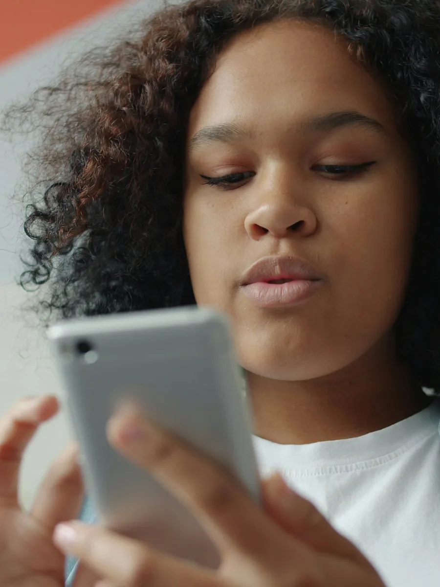 Une jeune femme regarde l'écran de son smartphone, de près