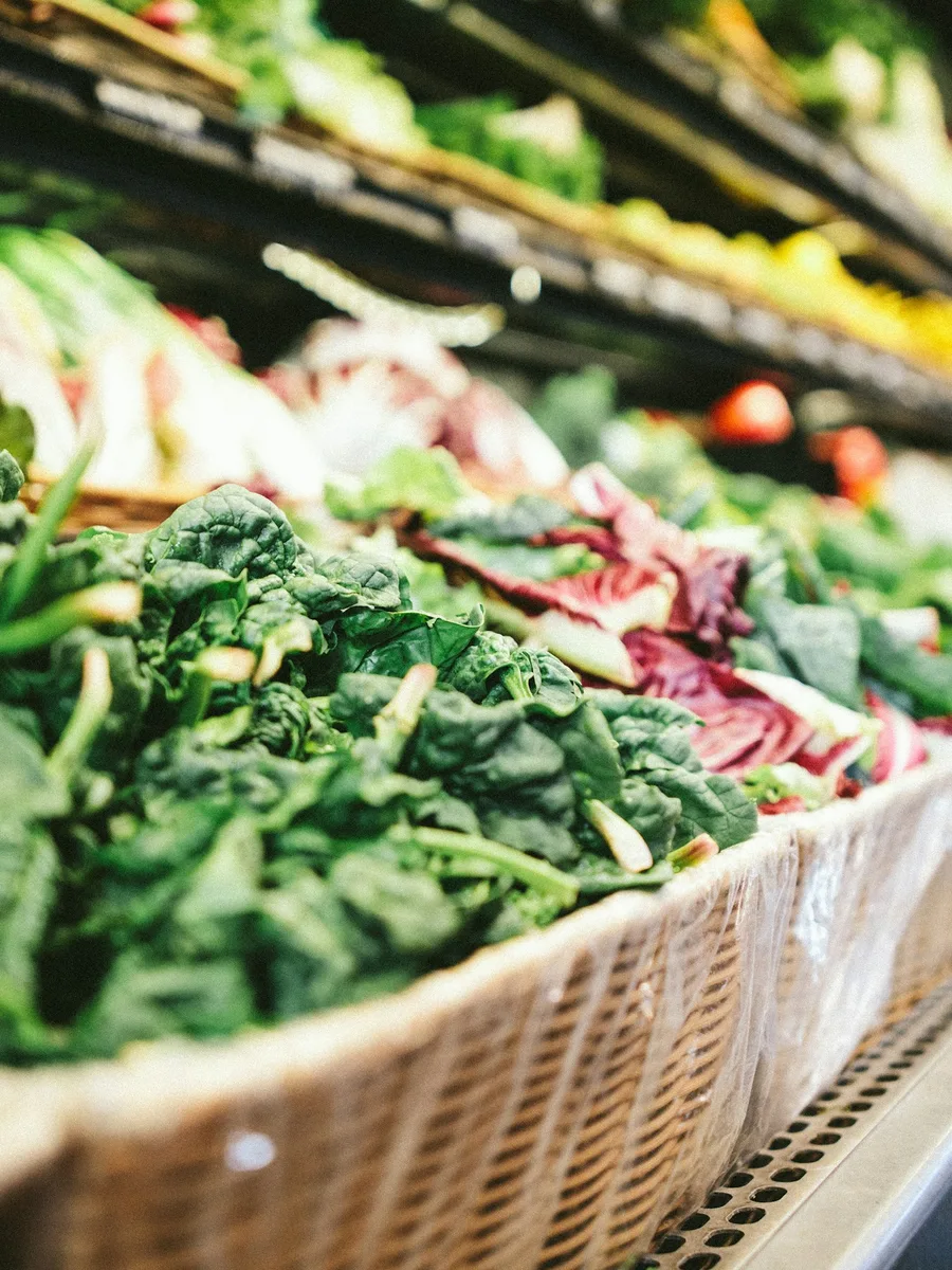 Un rayon de légumes frais sur un présentoir réfrigéré à plusieurs niveaux.