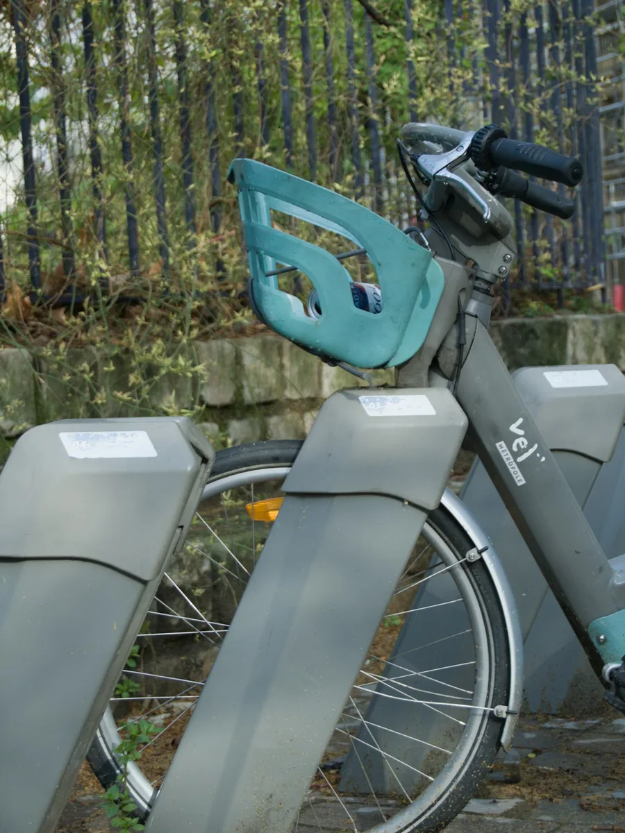 Un vélo en libre-service bleu accroché à sa borne de station