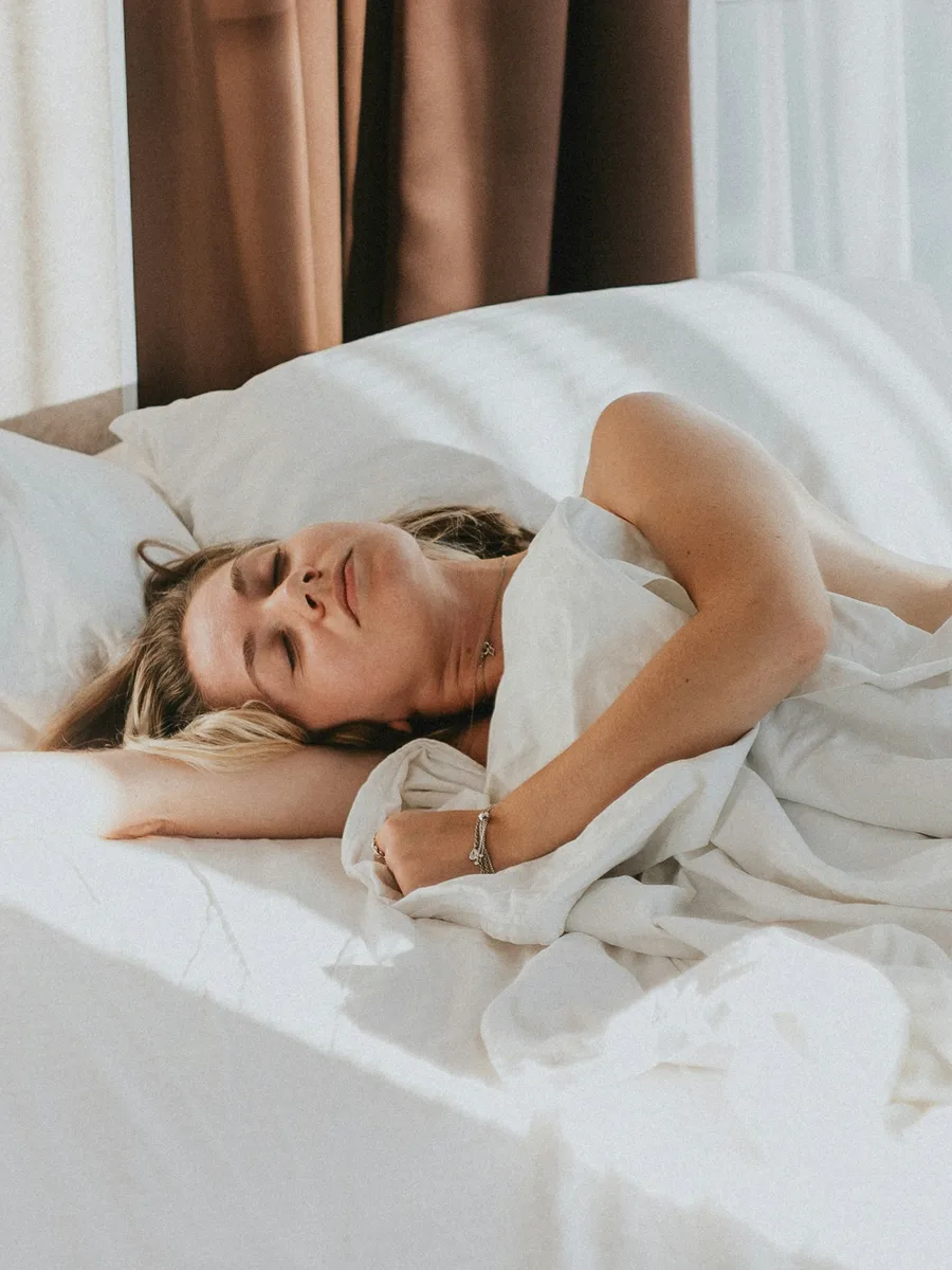 Une femme allongée dans un lit, les yeux fermés