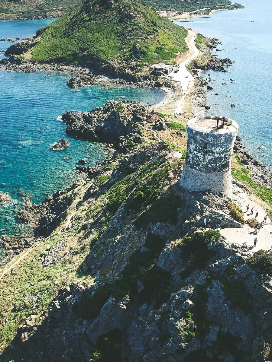 Vue aérienne de la tour de la Parata et de sa presqu'île rocheuse au-dessus d'une mer turquoise, en Corse