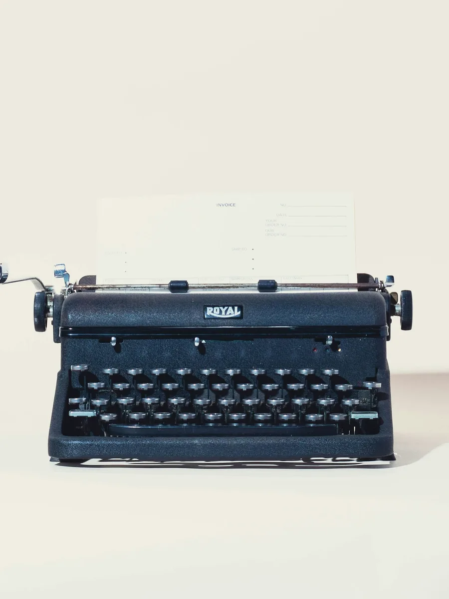 Une machine à écrire ancienne avec une feuille de papier glissée dans le rouleau