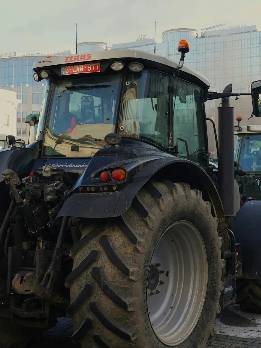 Des tracteurs garés en file dans une rue, devant des immeubles