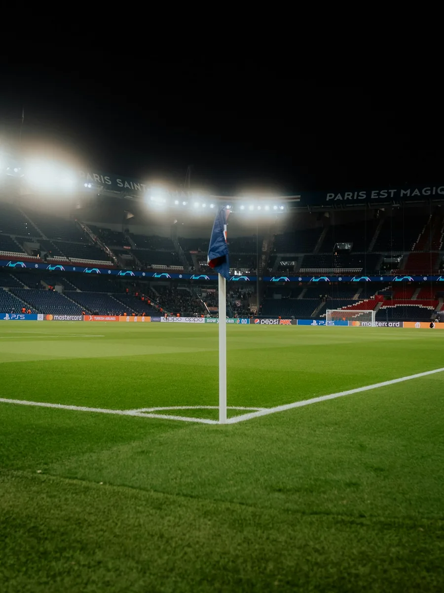Un drapeau de corner sur la pelouse d'un stade éclairé de nuit