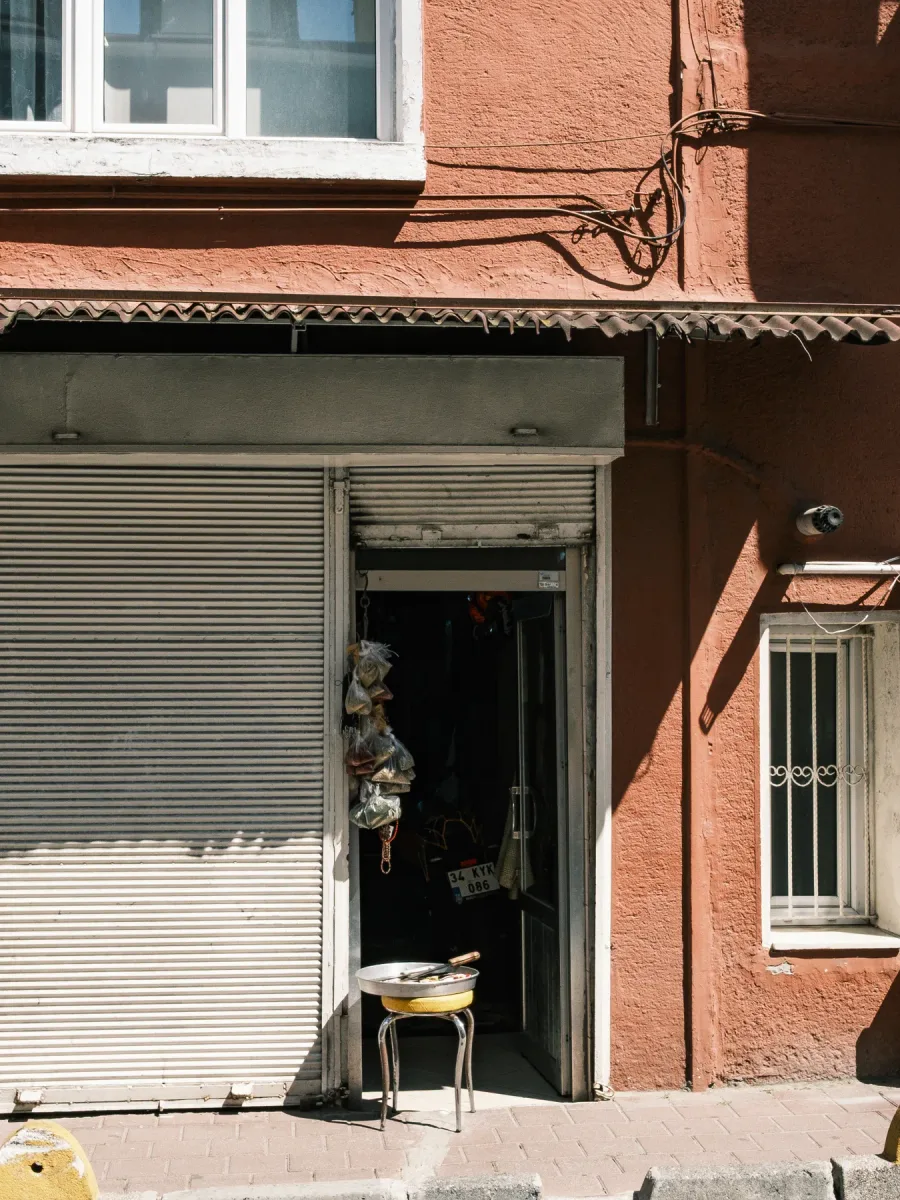 Une femme passe devant la devanture fermée d'un petit commerce, par une journée ensoleillée